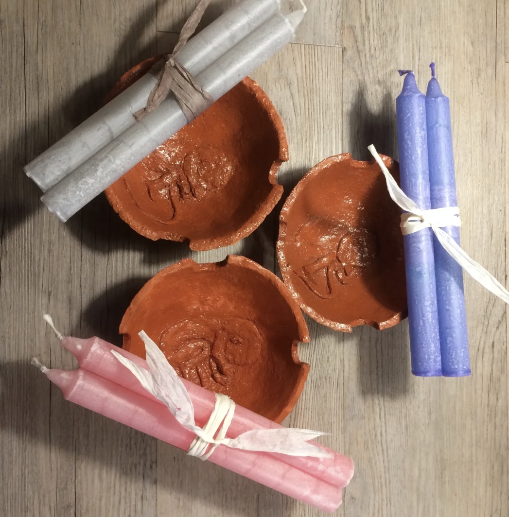Drie terracotta cord burning schaaltjes met brandende kaarsen