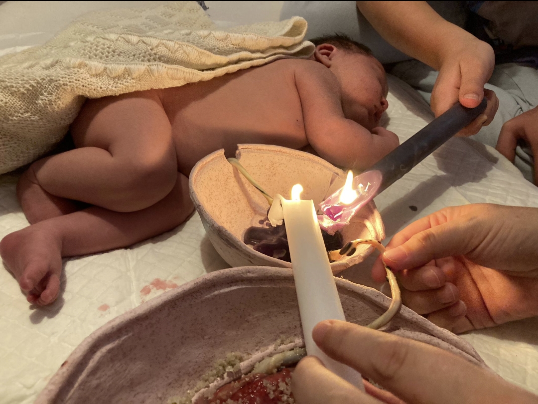 Baby tijdens een cord burning ritueel, waarbij de navelstreng doorbrand wordt